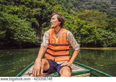 Man Tourist In Trang An Scenic Landscape Complex In Ninh Binh Province, Vietnam A Unesco World Herit