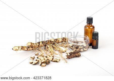 Fresh And Dried Acorus Calamus Roots, Also Known As Sweet Flag, Isolated On Light Background. Bottle