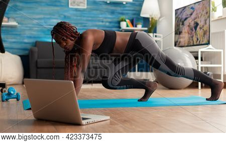 Fit Strong Black Woman Doing Running Plank On Fitness Mat On Living Room Floor, Practicing Muntaing 