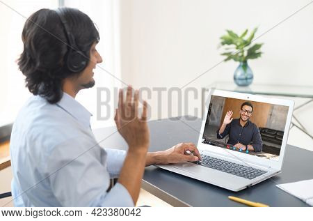 Two Indian Male Office Employee Greeting Each Other, Talking Online Via Video Connect On A Laptop, B