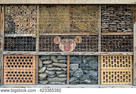 House For Insects. A Box Made Of Bark, Straw And Stones. Bricks, Cones And Bamboo For The Insect To 