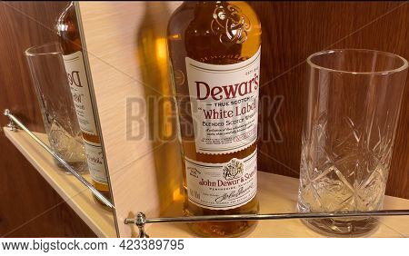 Bottle Of Dewar's White Label On Shelf In Bar, Brown Background With Reflection. Scottish Cognac. Pe