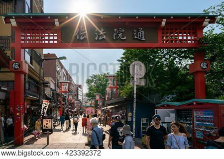 Tokyo, Japan - 05.13.2019: Busy Steet With Many Shops Viewed Through One Of Torii Gates In The Compl