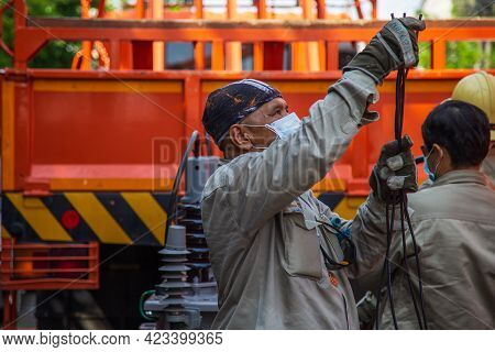 Nonthaburi, Thailand- May 19, 2021: Electrical Wireman Are  Preparing Cable Before Install Cable To 