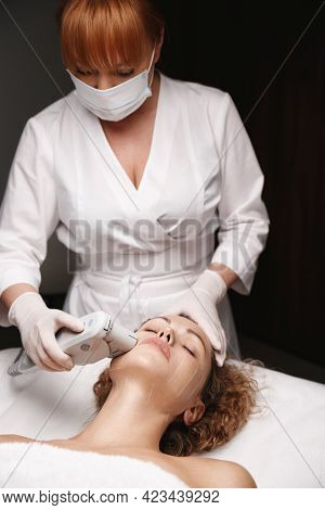 Hardware Cosmetology And Face Lift Concept. Doctor Beautician Using Ultrasound Hufu Device To Reduce