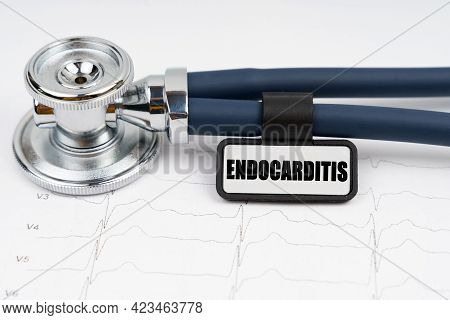 Medicine And Health Concept. On The Cardiogram Is A Stethoscope And A Plate With The Inscription - E
