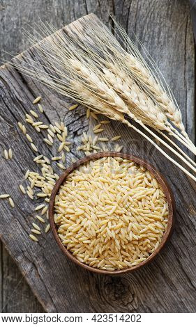 Raw Barley Noodle In Bowl On Wooden Background With Wheats, Uncooked Food Concept