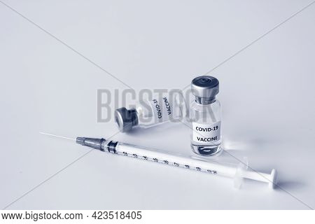 Vial Of Covid-19 Vaccine And 1 Ml Plastic Syringe With Needle Isolated On The White Background