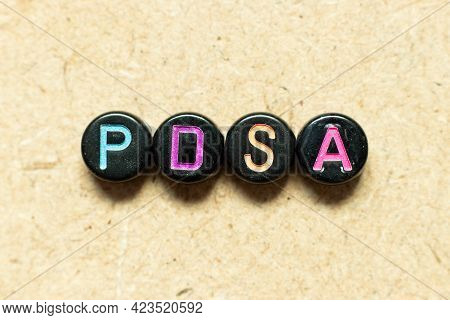 Black Color Round Alphabet Letter Block In Word Pdsa (abbreviation Of Plan Do Study Act) On Wood Bac