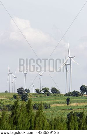 Rear View Man Engineer Wearing Personal Protective Equipment Working In Wind Turbine Farm Background
