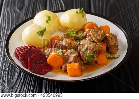 Swedish Traditional Beef Kalops Garnished With Boiled Potatoes And Pickled Beets Close-up In A Plate
