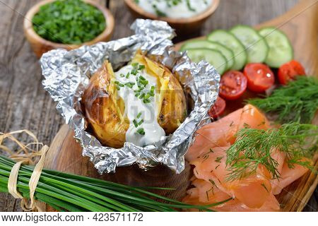 Baked Jacket Potato Fresh From The Oven Served With Chives Sour Cream And Smoked Salmon