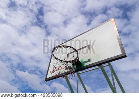 Side View Of Outdoor Basketball Backboard On A Cloudy Morning.