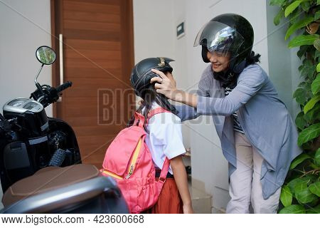 Mother Taking Her Daughter To School By Motorcycle In The Morning