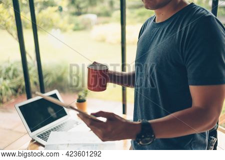 Tourist Planning Vacation Hold Cup Of Coffee And See Tablet Screen And Trvel Accessories Around On T