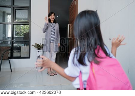 Kid Waving Goodbye To Mother At Home Before Going To School
