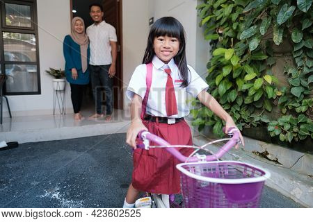 Girl Primary Student Going To School By Riding A Bike In The Morning