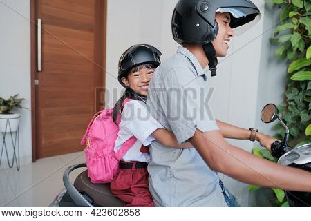 Father Taking His Daughter To School By Motorcycle In The Morning
