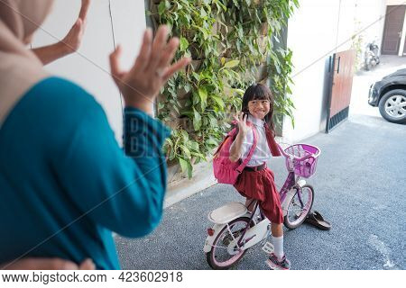 Girl Primary Student Going To School By Riding A Bike In The Morning