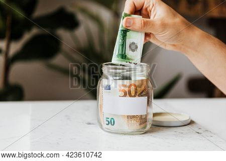 Saving money in a jar during the COVID-19 pandemic