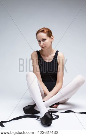Sensual Professional Female Ballet Dancer In Body Suit Posing With Outstretched Laces  On Floor. Ver
