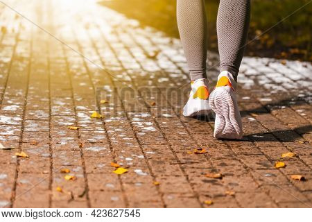 Jogging Concept. Closeup Of Active Female Runner Feet During Running Exercise Outdoors. Horizontal I