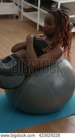 Athletic Black Woman Doing Morning Fitness Workout In Living Room Exercising Abdominal Muscle Sittin