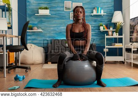 Sportive Active Strong Black Woman Sitting On Stability Ball Resting, After Intense Training In Home