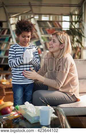 Happy caucasian nanny babysitting afro american boy at home