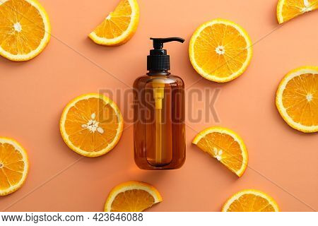 Amber Glass Pump Bottle With Natural Shampoo With Vitaminc C And Sliced Orange Top View.