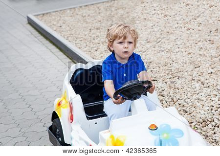 Todder menino brincando com carro de brinquedo grande