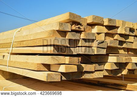 Stacked Lumber On Blue Sky.folded Wood.closeup Wooden Boards.the Surface Of The End Of The Board.lot