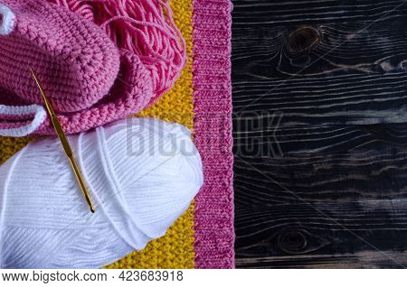 Knitting Accessories A Skein Of Yarn A Knitting Hook And A Knitting Blank On A Dark Wooden Backgroun