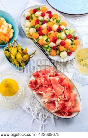 Cucumber and melon salad with raspberries and Prosciutto with grilled peppers. Summer appetizers