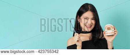 Woman Holding Toothbrush And Dental Teeth Model. Oral Health Care Concept.