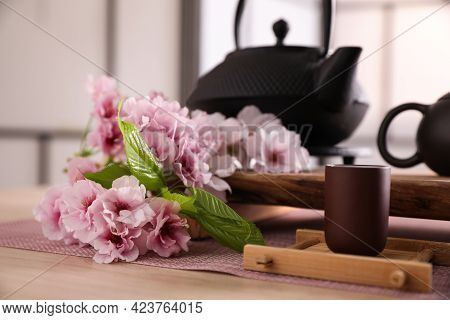 Cup And Sakura Flowers On Wooden Table. Traditional Tea Ceremony