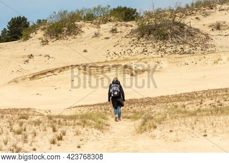Nida, Lithuania - May 23 2021: Girl Visiting Sand Dunes In Nida, Klaipeda, Lithuania, Europe. Curoni