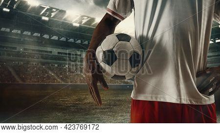 Cropped Male Soccer, Football Player Standing With Ball At The Stadium During Sport Match On Light S