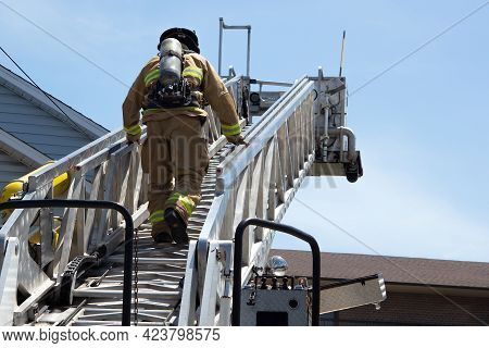 Firefighter Climbing A Ladder Fireman At Work Extinguishing Fire