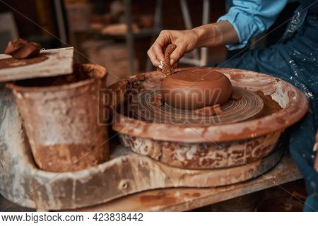 Unrecognized Female Ceramicist Wearing Apron Working With Earthenware Materials On Special Equipment