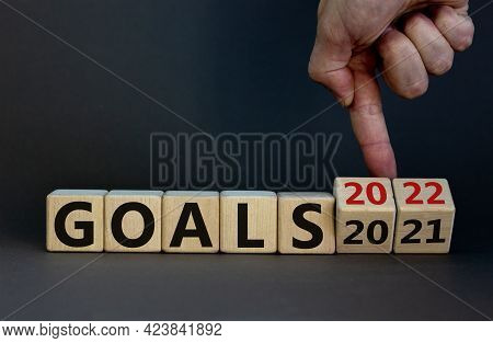 Goals Planning 2022 Symbol. Businessman Turns Wooden Cubes And Chages Words 'goals 2021' To 'goals 2