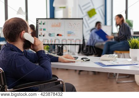 Busy Paralysed Handicapped Team Leader Answering Phone Talking With Partner Typing On Computer Expla