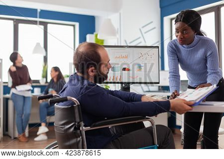 Black Manager Woman Working With Financial Documents Checking Graphs Talking With Paralysed Team Lea