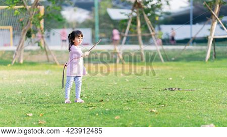 Asian Girl Is Having Fun In Battle By Using Sheath Of Koon Tree To Make Sword Knife. Child Play Role