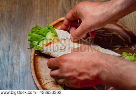 Male Hands Swerve Pita With Vegetables And Cheese. Vegetarian Roll.