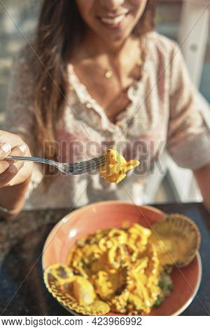 Beautiful Young Girl Tasting A Delicious Rice With Seafood, Peruvian Food Called 