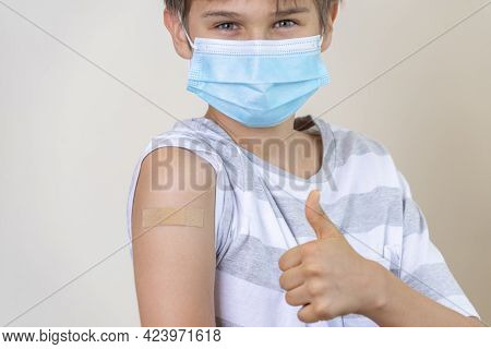 Teenager With Adhesive Bandage Plaster On His Arm After Vaccination Showing Thumb Up Sign. Injection