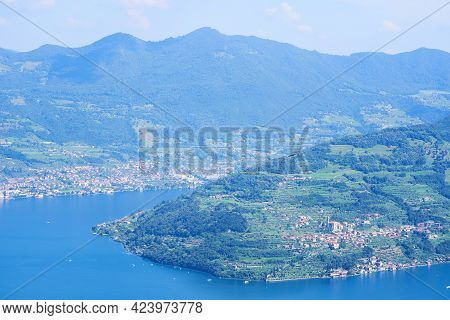 Aerial View Of Lake Iseo, Forested Mountains, Various Villages Scattered Along The Mountain Slopes A