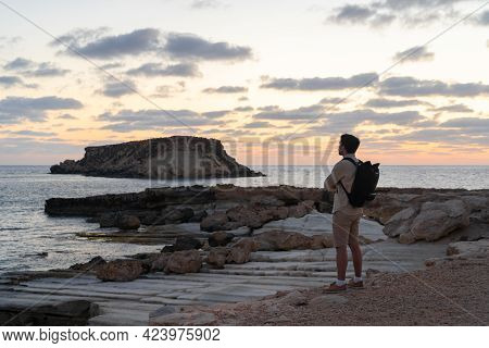 Male Tourist With Backpack Watching Beautiful View Of Yeronisos Holy Island Near Coast Agios Georgio