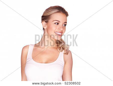 Beautiful blond girl with a lovely warm friendly smile standing looking sideways against a white background with copyspace